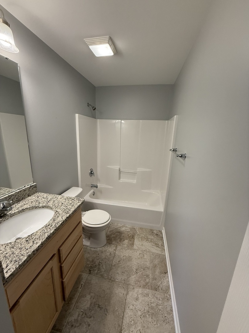 1603 Riverside Circle Dixon, IL 61021 - Photo 13 of 20 a bathroom with a granite countertop sink toilet a mirror and shower