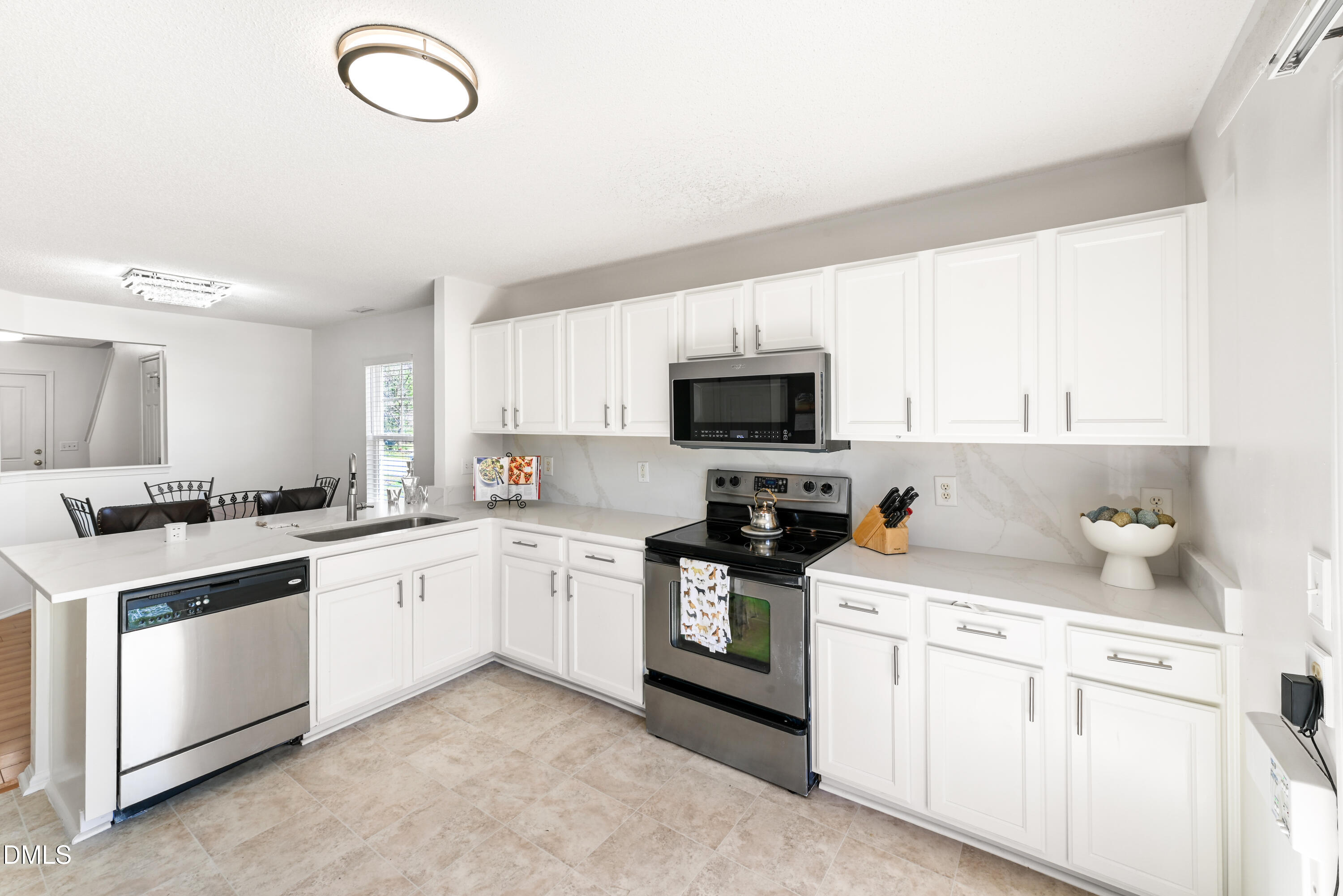 1012 Naylor Road Knightdale, NC 27545 - Photo 6 of 33 a kitchen with white cabinets stainless steel appliances and sink