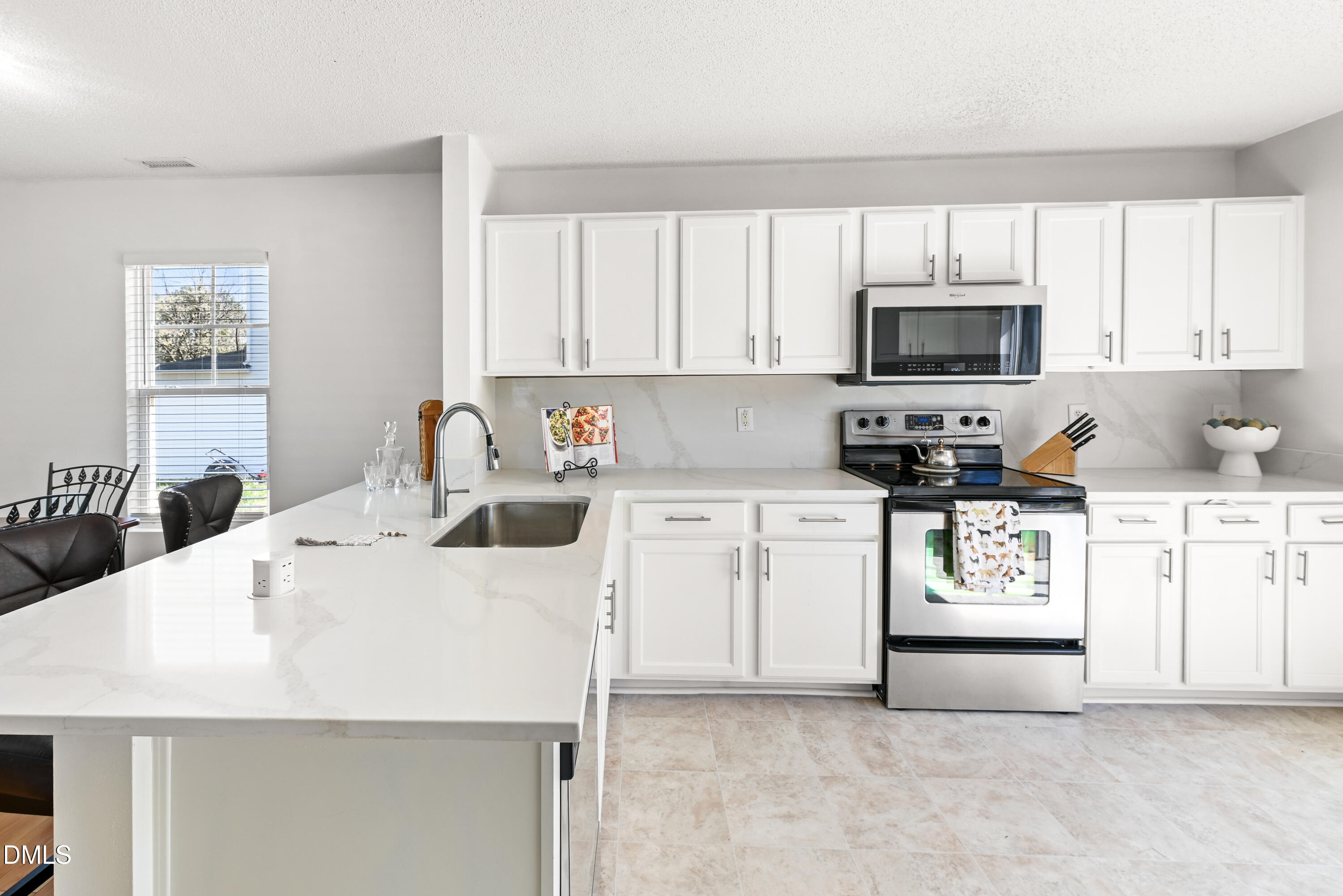 1012 Naylor Road Knightdale, NC 27545 - Photo 7 of 33 a kitchen with granite countertop a stove a sink a microwave a refrigerator and cabinets