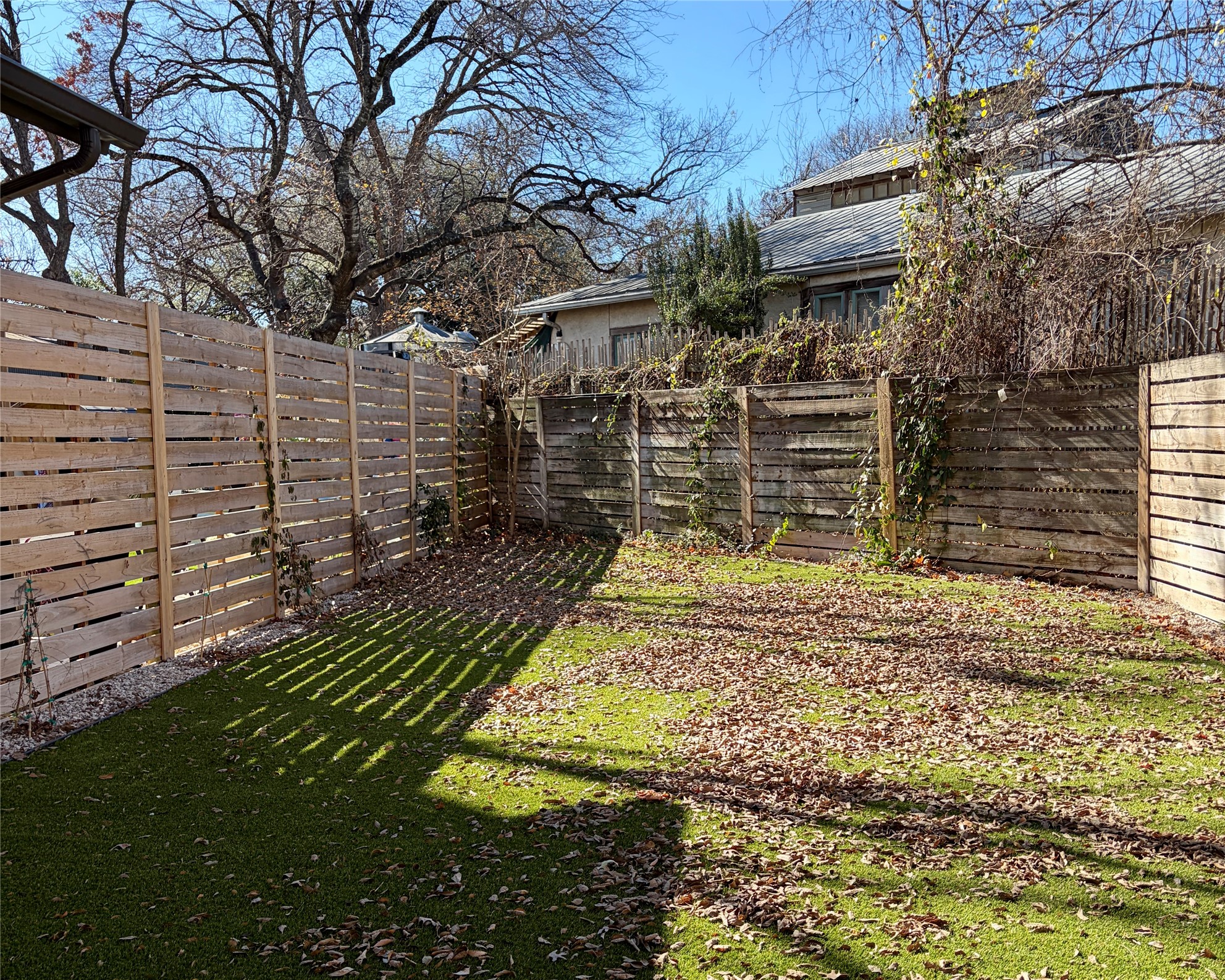 1515 Hether Street, Unit B Austin, TX 78704 - Photo 29 of 30 A private yard with new fencing offers a verdant lawn, ideal for outdoor enjoyment.