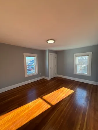 a view of a room with wooden floor and window