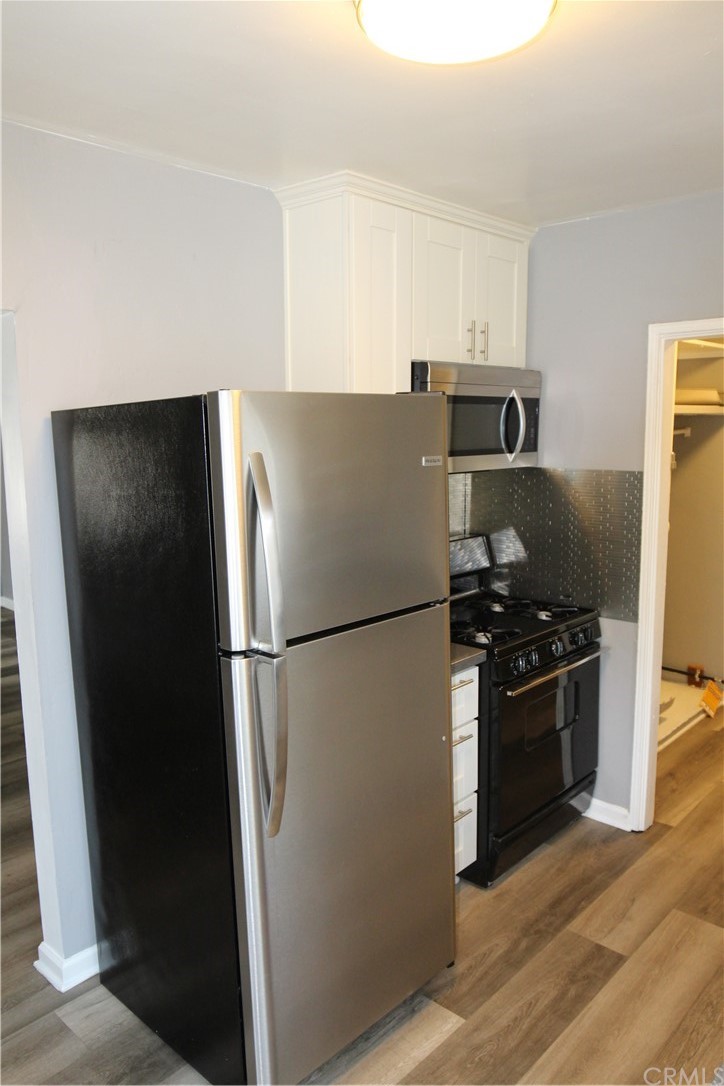 4944 Bleecker Street Baldwin Park, CA 91706 - Photo 6 of 11 a white refrigerator freezer and a stove sitting inside of a kitchen