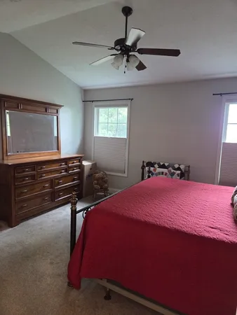 a bedroom with a bed and a chandelier fan