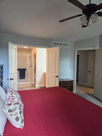 a bedroom with a large bed and a chandelier