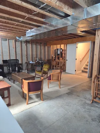 a living room with patio furniture and a grill