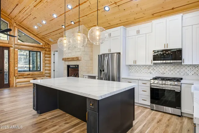 a room with a chandelier and wooden floor