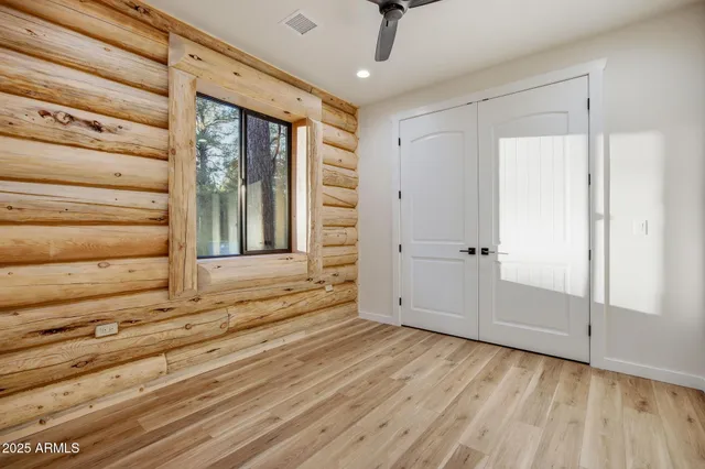 an empty room with wooden floor and natural light