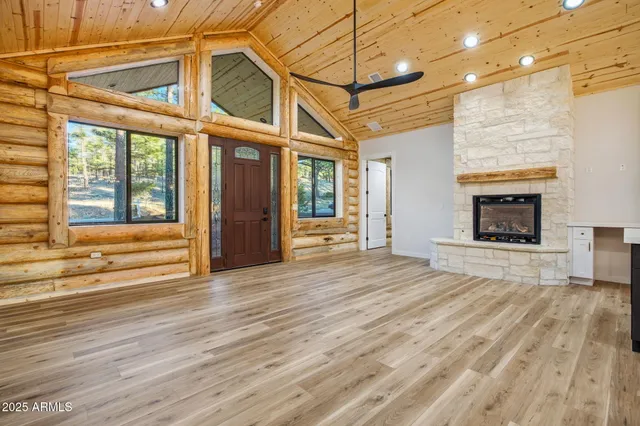 a view of empty room with wooden floor and fireplace