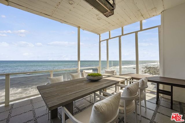 a kitchen with stainless steel appliances granite countertop a dining table and chairs