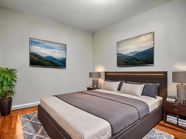 a bedroom with bed and wooden floor