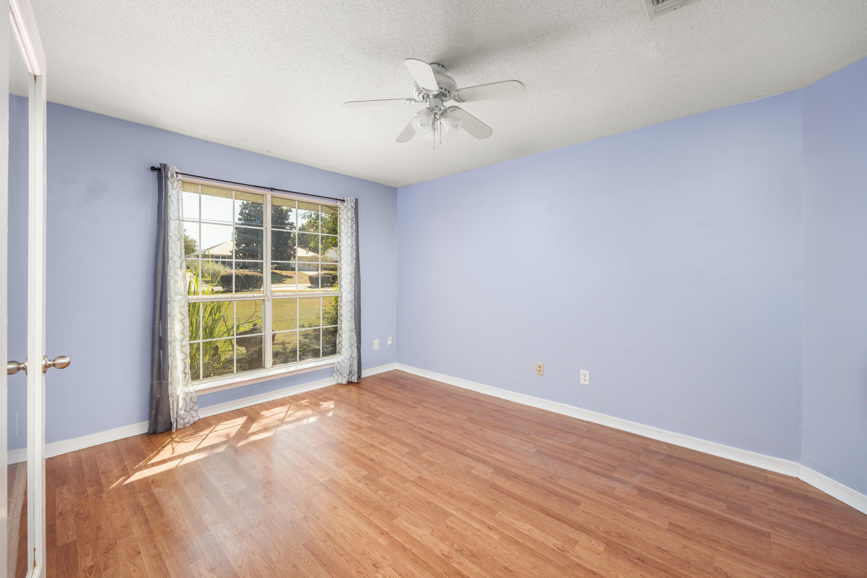 4860 Orlimar Street Crestview, FL 32536 - Photo 7 of 36 an empty room with wooden floor and windows