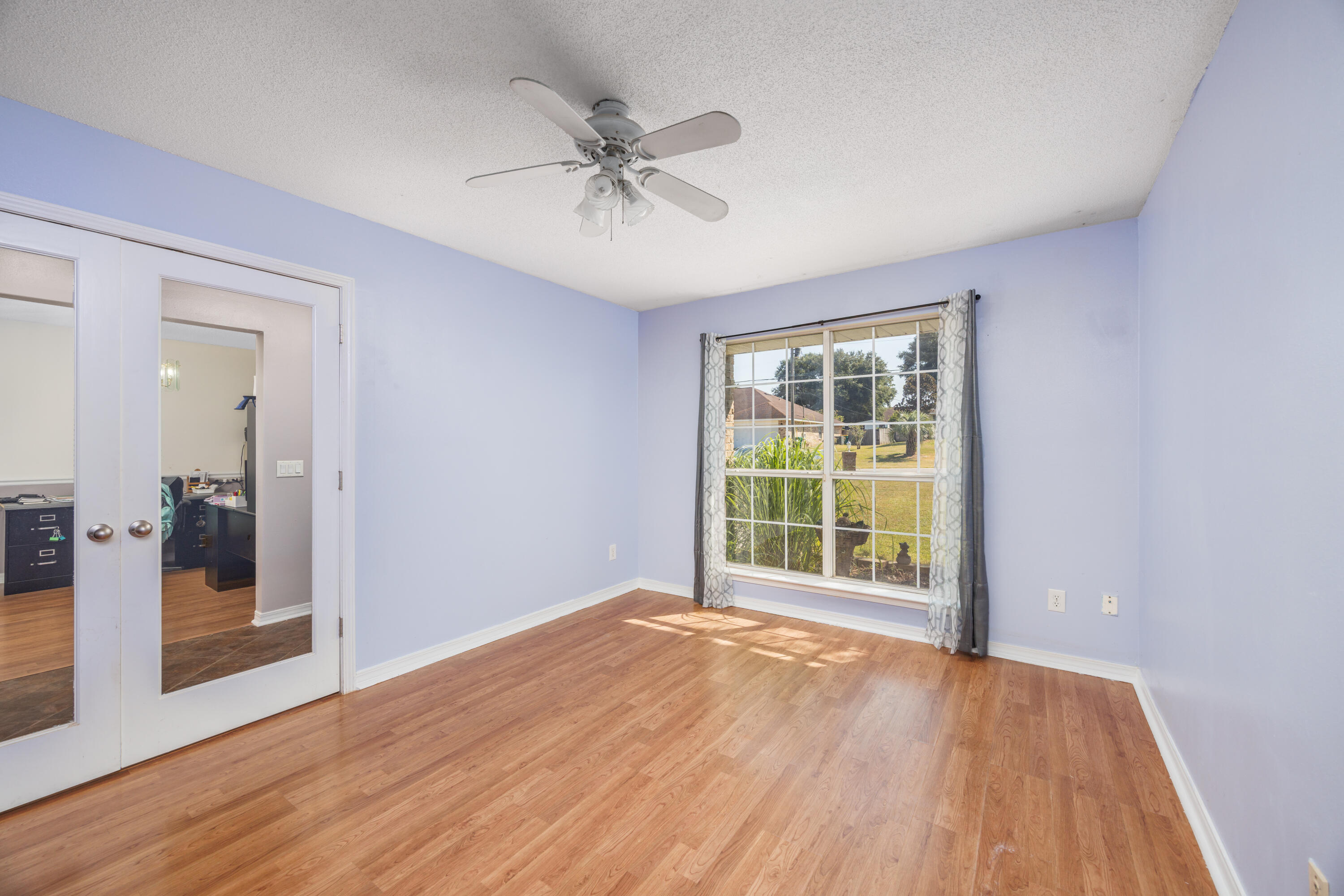 4860 Orlimar Street Crestview, FL 32536 - Photo 8 of 36 a view of an empty room with wooden floor and a window