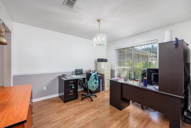 a view of a workspace with furniture and a window