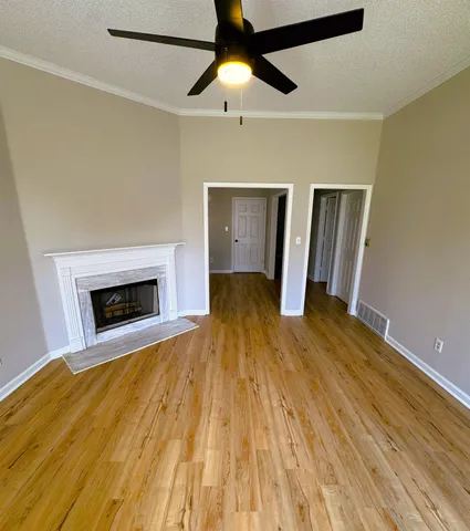 a view of empty room with wooden floor and fireplace