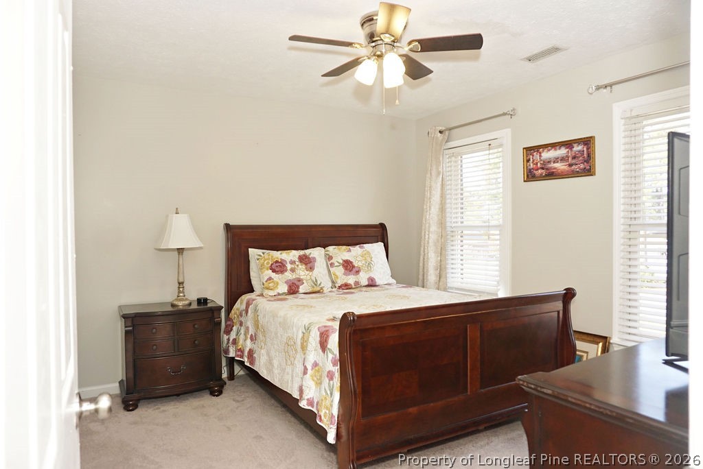 8363 King Road Fayetteville, NC 28306 - Photo 27 of 44 a bedroom with a bed and a chandelier