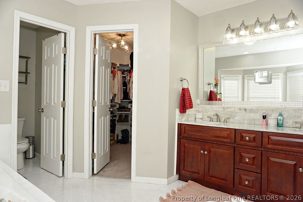 8363 King Road Fayetteville, NC 28306 - Photo 38 of 44 a bathroom with a granite countertop sink vanity and mirror