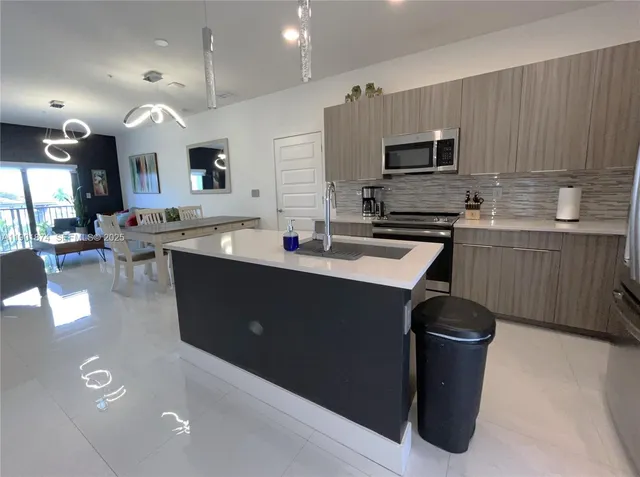 a kitchen with stainless steel appliances granite countertop a sink a stove and a refrigerator