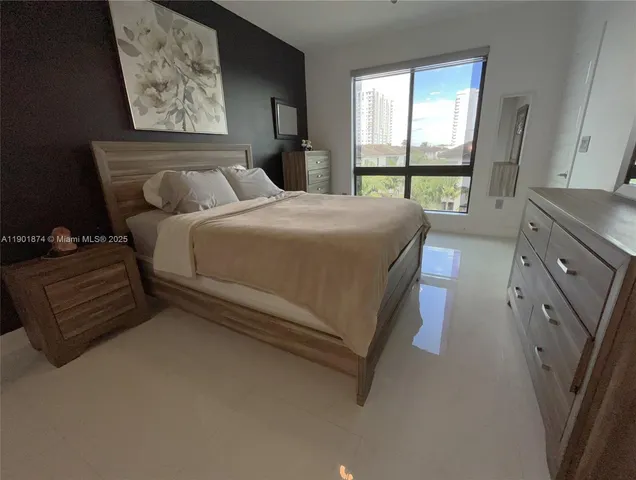 a bedroom with a bed and a dresser next to a window