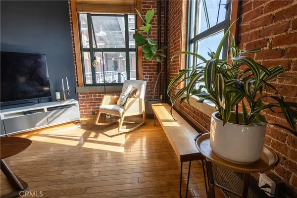 a living room with furniture a flat screen tv and floor to ceiling windows
