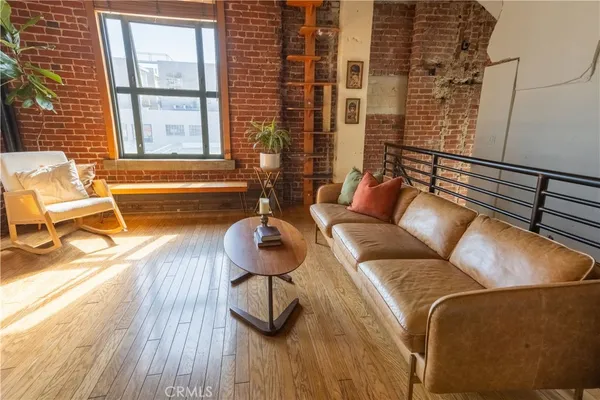 a living room with furniture a flat screen tv and a large window