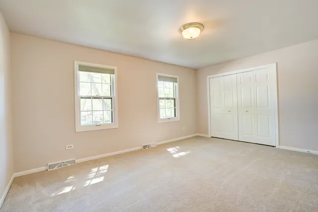 a spacious bedroom with a bed a couch and a window