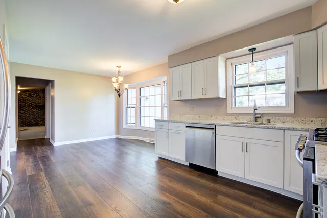a kitchen with granite countertop white cabinets and white appliances