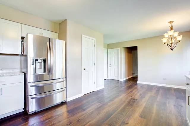 a kitchen with granite countertop a refrigerator and a stove top oven