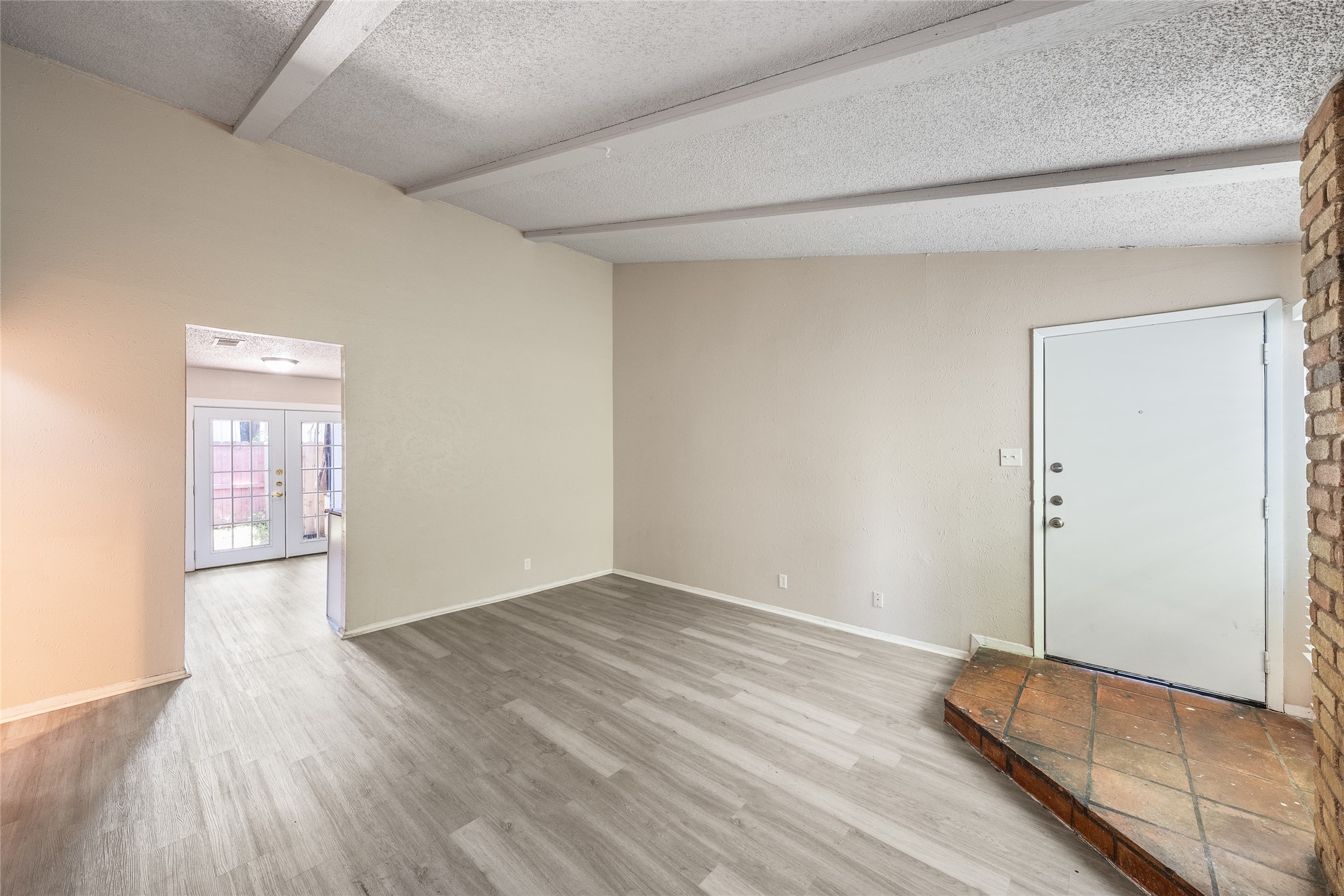 1111 West Rundberg Lane Austin, TX 78758 - Photo 5 of 16 Enter into a vast living space featuring robust wood-style flooring and exposed ceiling beams.