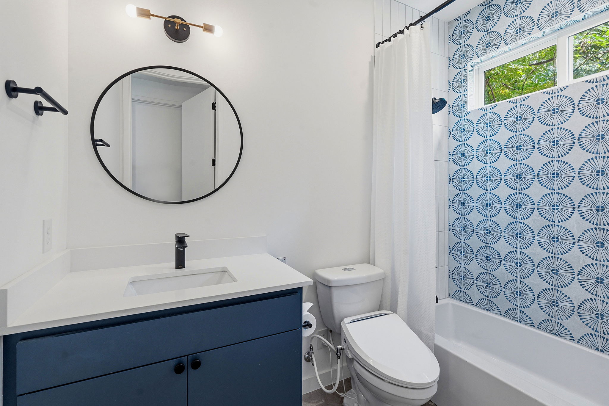 1707 Deloney Street, Unit 2 Austin, TX 78721 - Photo 23 of 26 Modern bath features a bright vanity and vibrant blue-tiled shower, creating a crisp, clean aesthetic.