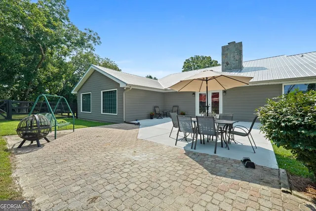 a patio with a table and chairs under an umbrella