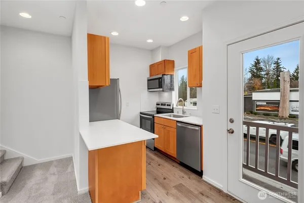 a kitchen with stainless steel appliances kitchen island granite countertop a stove a sink and a refrigerator