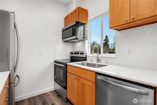 a kitchen with stainless steel appliances granite countertop a sink stove and microwave