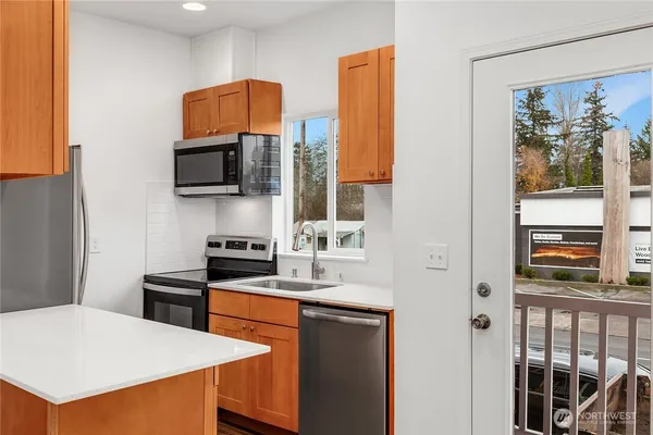a kitchen with stainless steel appliances a stove microwave and a refrigerator