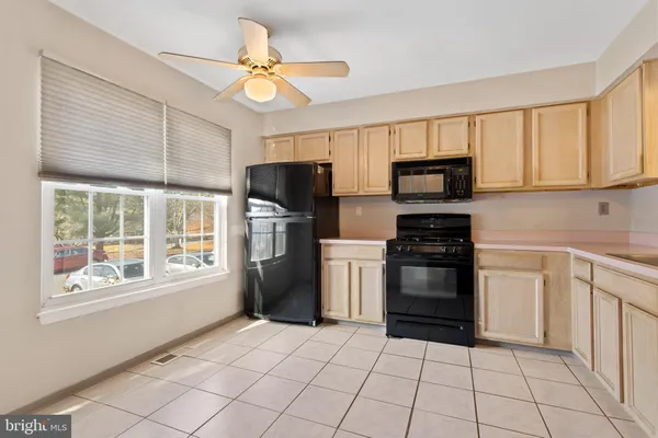 a kitchen with a stove a refrigerator and cabinets