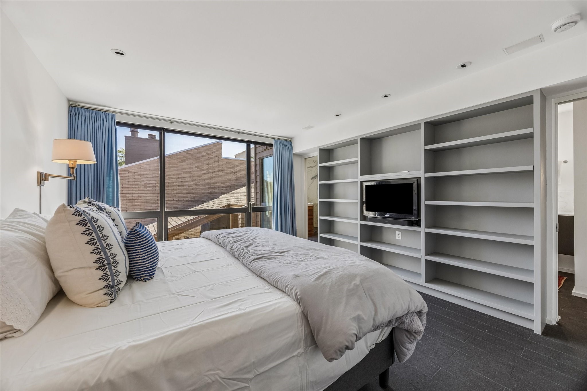 1007 Barkdull Street, Unit 4 Houston, TX 77006 - Photo 17 of 28 Primary bedroom with floor to ceiling windows (with shades and blackout drapery) also had built in shelving.