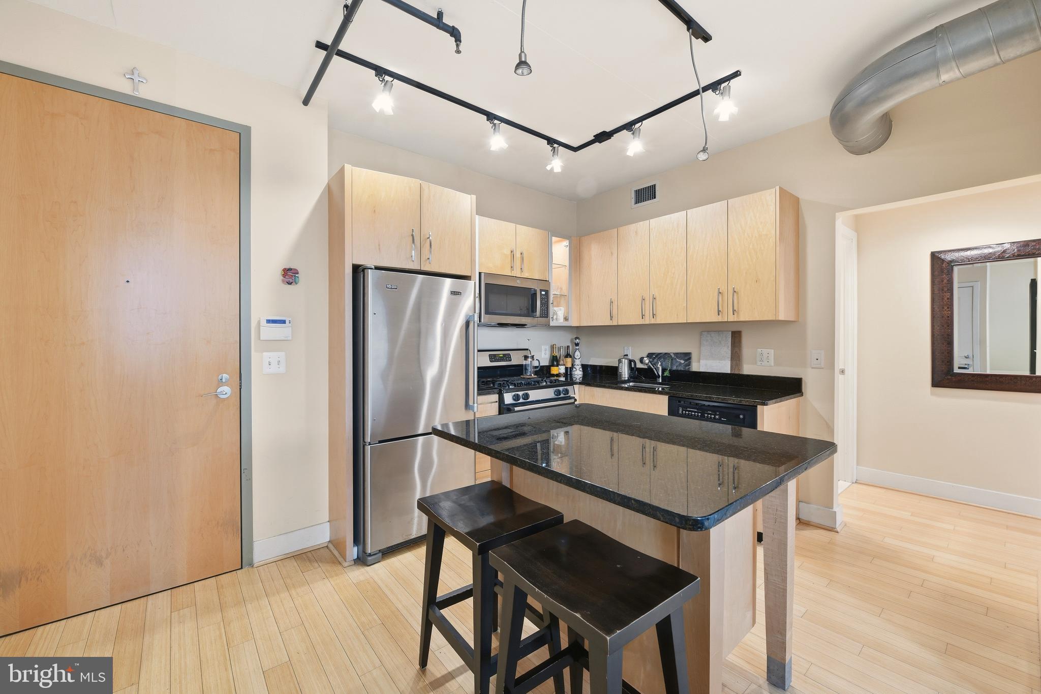 1444 Church Street Northwest, Unit 206 Washington, DC 20005 - Photo 11 of 19 a kitchen with stainless steel appliances granite countertop a refrigerator a sink dishwasher a stove and white countertops with wooden floor