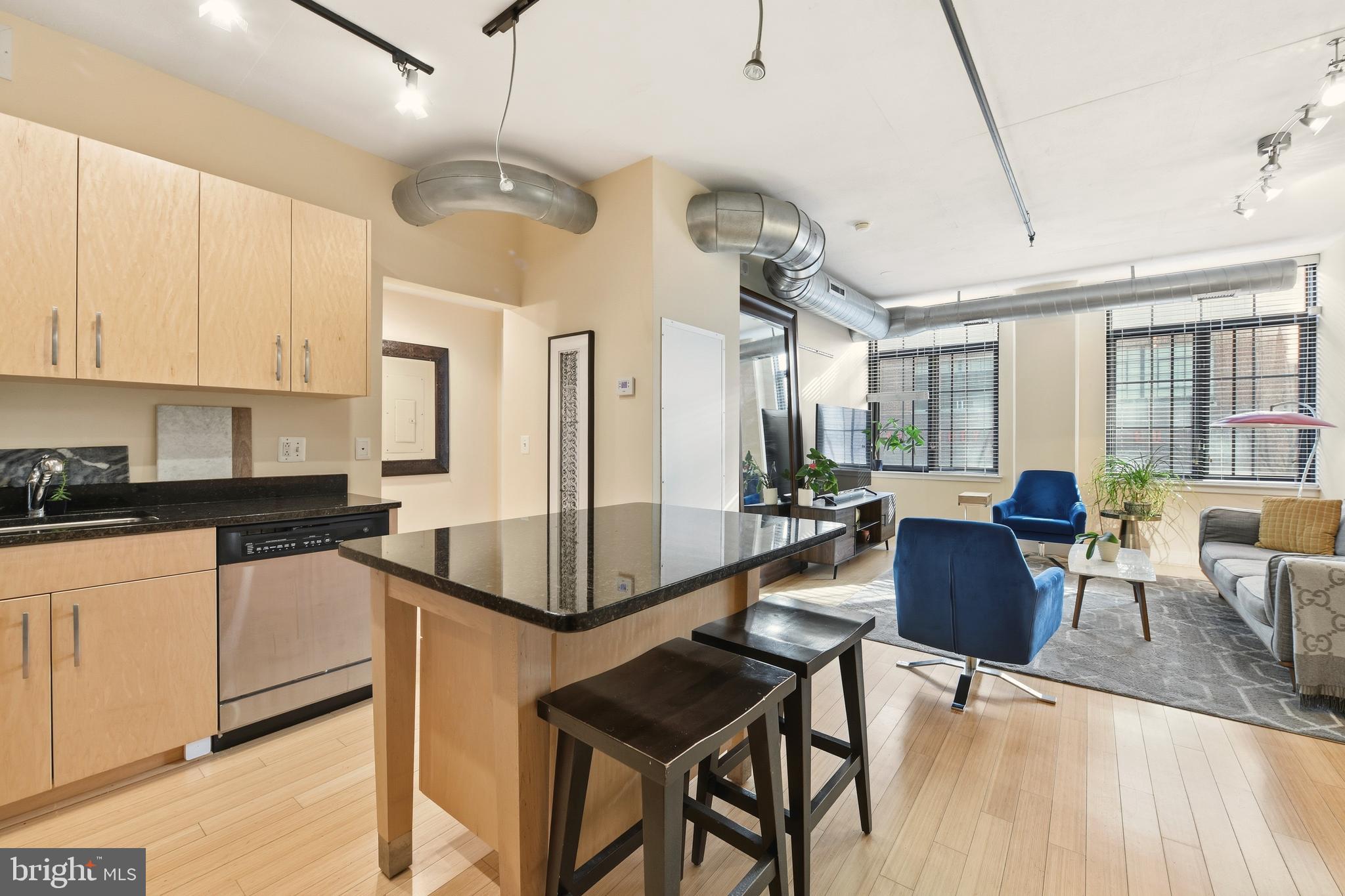 1444 Church Street Northwest, Unit 206 Washington, DC 20005 - Photo 12 of 19 a kitchen with stainless steel appliances granite countertop a stove refrigerator a dining table and chairs with wooden floor