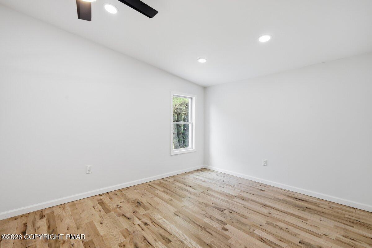 155 Blooming Grove Road Hawley, PA 18428 - Photo 25 of 41 an empty room with wooden floor cabinet and windows