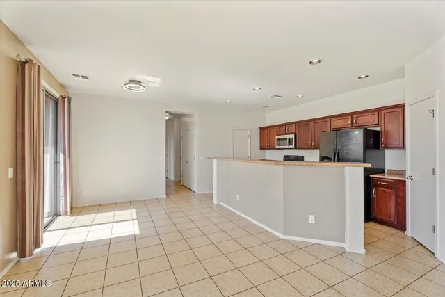 a view of a kitchen with a refrigerator and a stove top oven