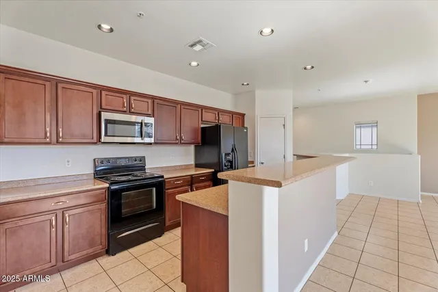 a kitchen with stainless steel appliances granite countertop a stove top oven a sink dishwasher and a refrigerator