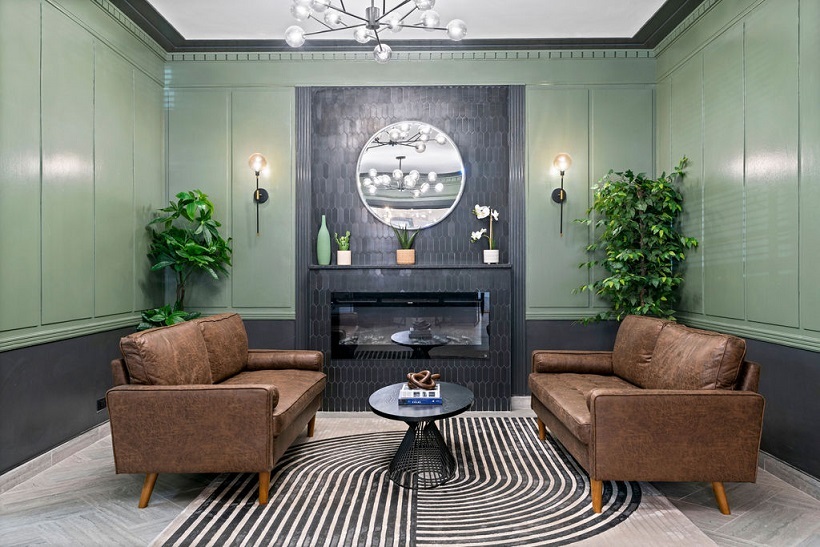 a living room with furniture a clock and a potted plant