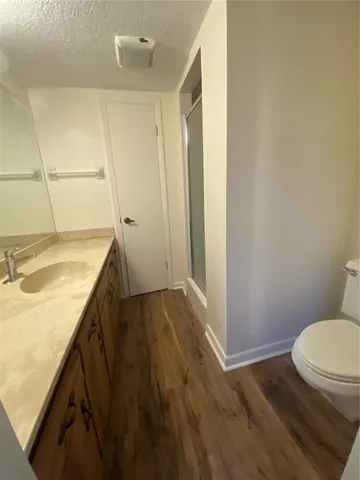a bathroom with a granite countertop sink toilet and shower