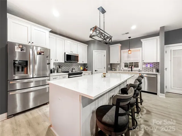 a kitchen with a center island stainless steel appliances cabinets and a counter top space