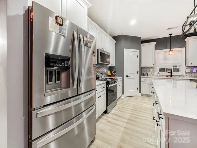 a kitchen with stainless steel appliances and refrigerator