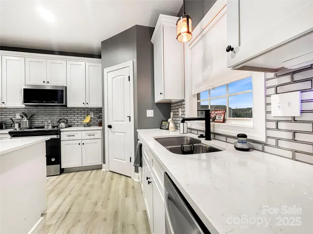 a kitchen that has a sink a stove and a microwave