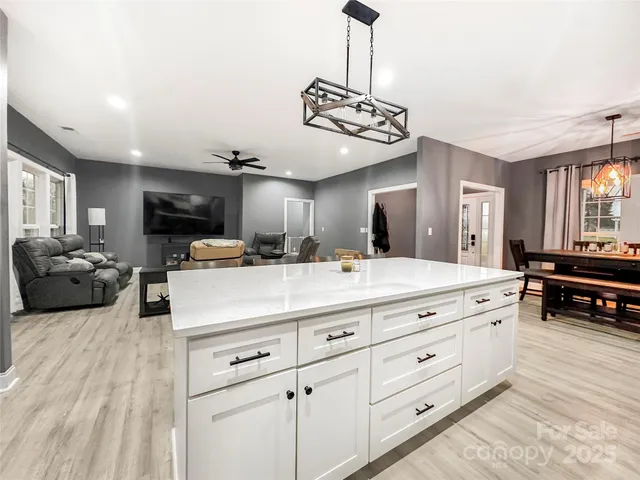 a kitchen with a counter space a sink and a large mirror