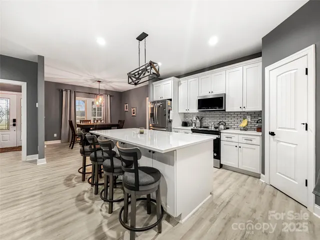 a kitchen with a table chairs refrigerator and microwave