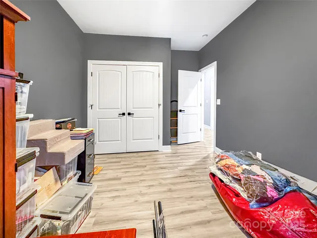 a bedroom with a bed and wooden floor
