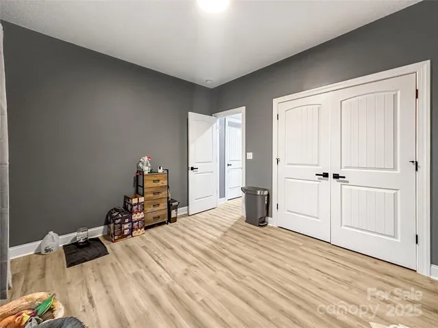 a room with a bed and wooden floor