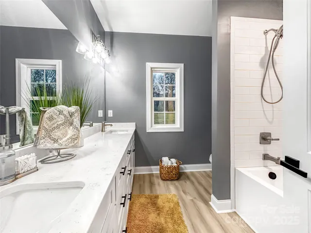 a bathroom with a tub sink and mirror